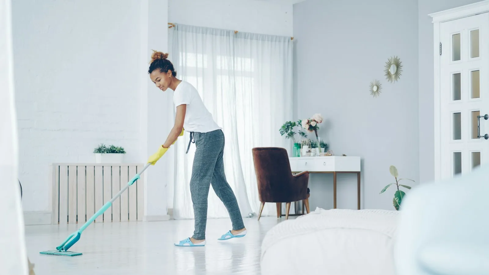 House cleaner mopping a bright living room floor