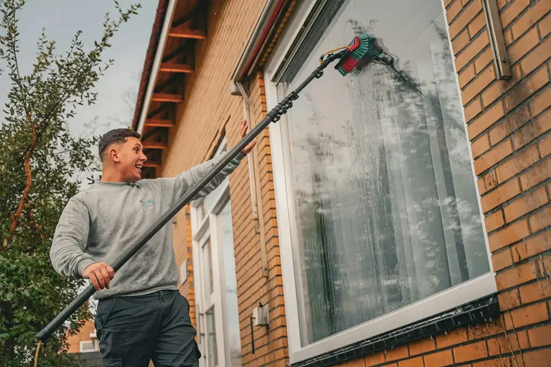 Washing a large window with a water-fed pole brush